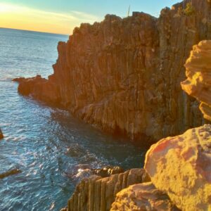 Scogliera di Rio Maggiore al tramonto. La roccia si tinge di arancio.